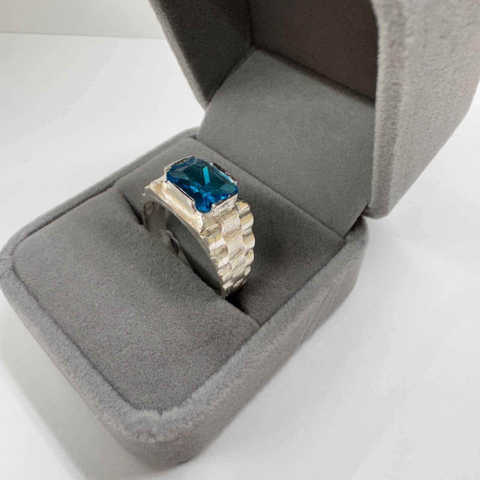 Anillo de plata con piedra azul presentado en estuche
